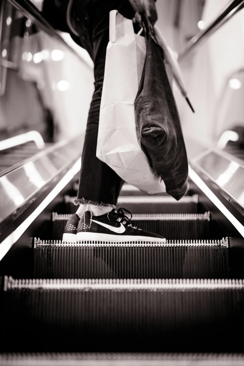 Shopper carrying bags on an escalator